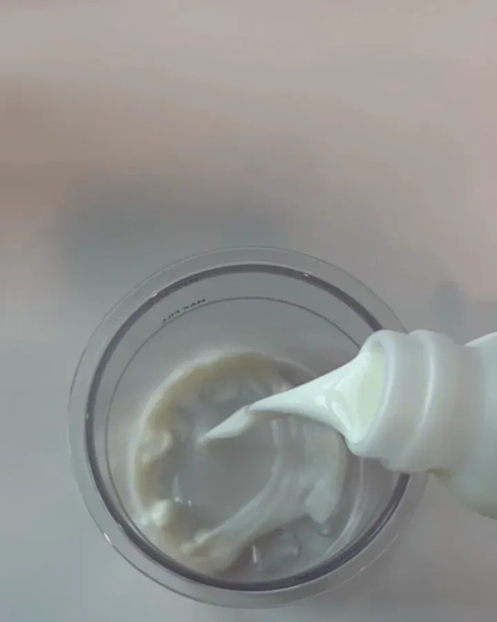 Melk og Frozti-pulver blandes med en visp i begeret til iskremmaskinen